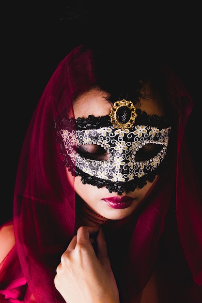 Girl with a red scarf on her head and a venetian mask