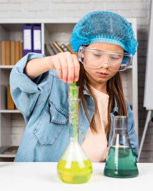 Free photo girl with safety glasses doing science experiments