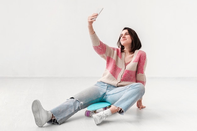 Girl with skateboard taking selfie