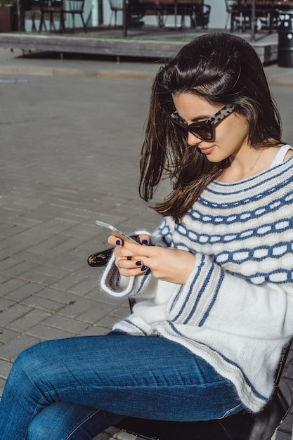 Free photo girl with a smartphone in her hands