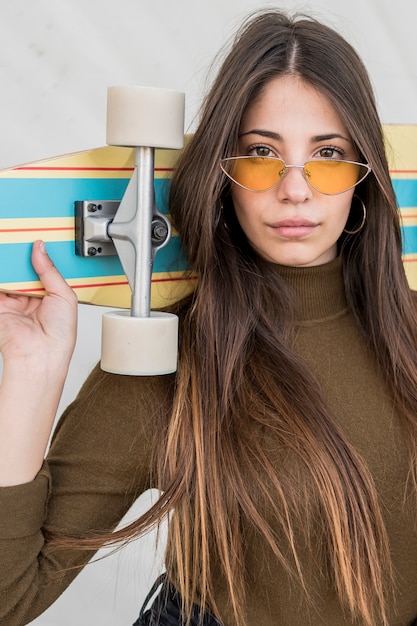 Free photo girl with sunglasses and skateboard