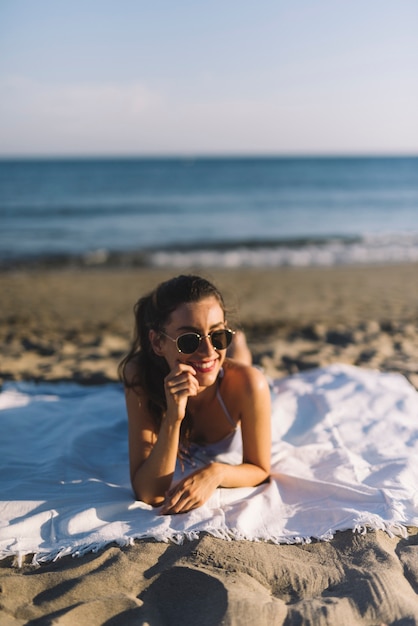 Free photo girl with sunglasses sunbathing at the beach