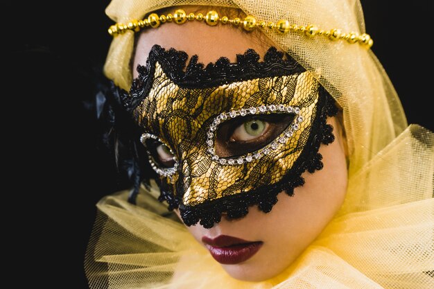 Girl with a yellow ornament on her head and a venetian mask