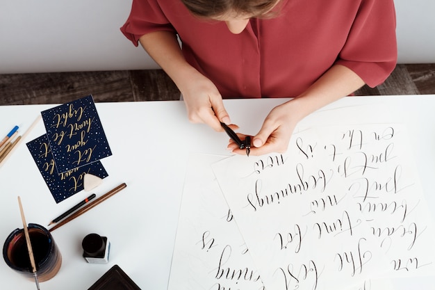 Free Photo girl writing calligraphy on postcards. art design.