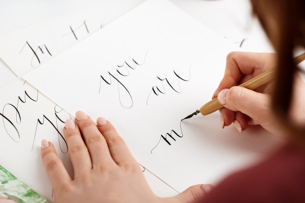 Free photo girl writing calligraphy on postcards. art design.