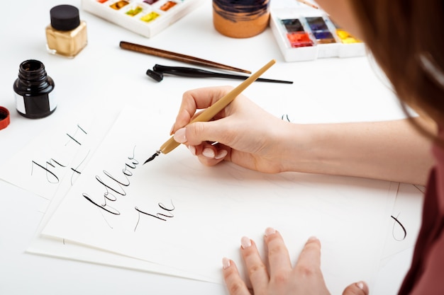 Girl writing calligraphy on postcards. Art design.