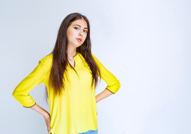 Girl in yellow shirt giving neutral poses.