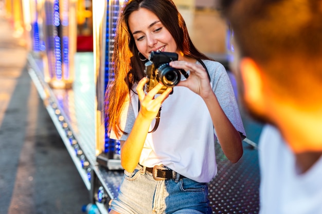 Girlfriend taking photo of boyfriend at fair