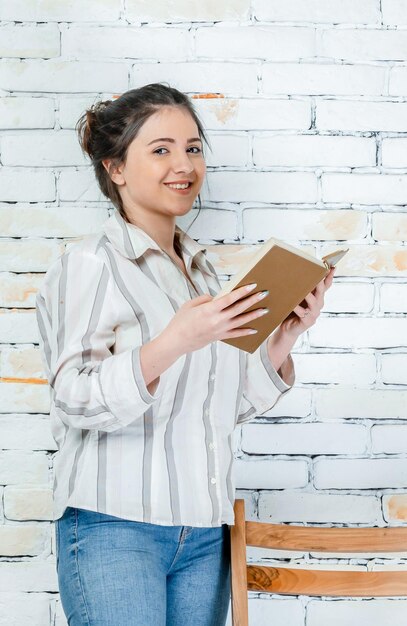 Girls in casual clothes holding book and smiling High quality photo