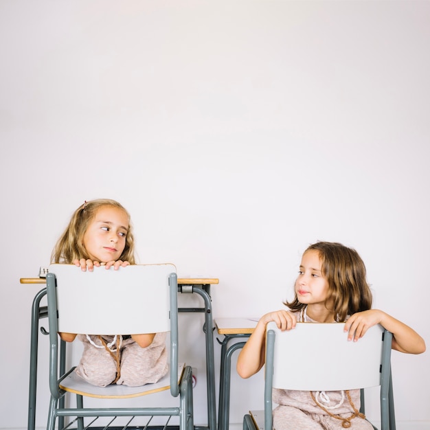 Free photo girls on chairs looking at each other