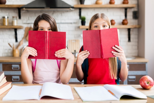 Free Photo girls covering faces with books