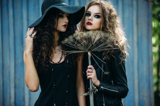 Girls disguised as witches posing with a broom