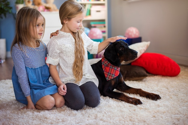 Free photo girls and dog sitting in a row