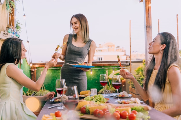 Free photo girls eating appetizers at rooftop party