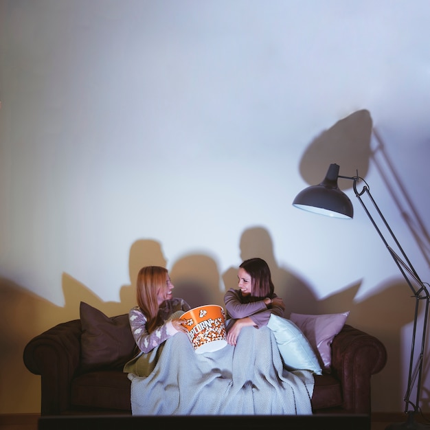 Free photo girls eating popcorn and having a movie night