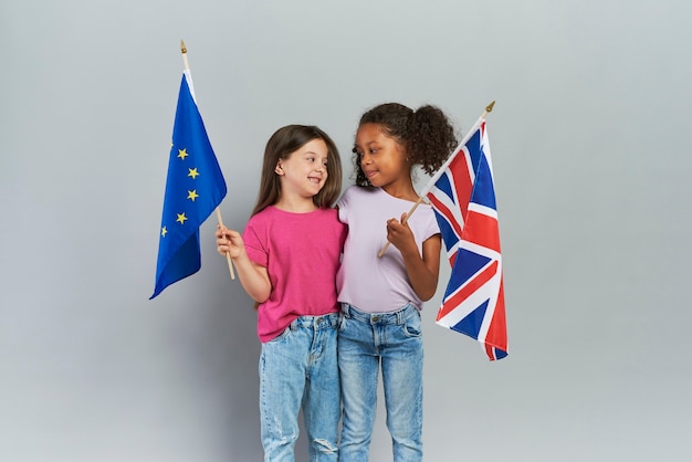 Free photo girls embracing and holding british and european union flags