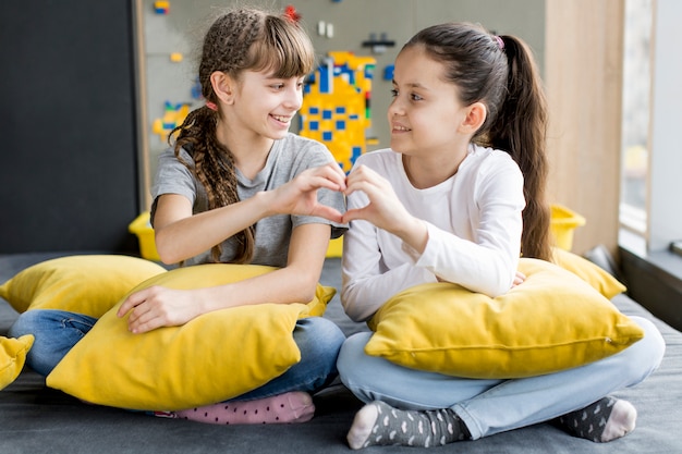 Girls forming heart with hands