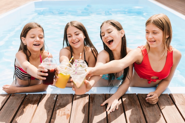 Free photo girls giving a toast in swimming pool