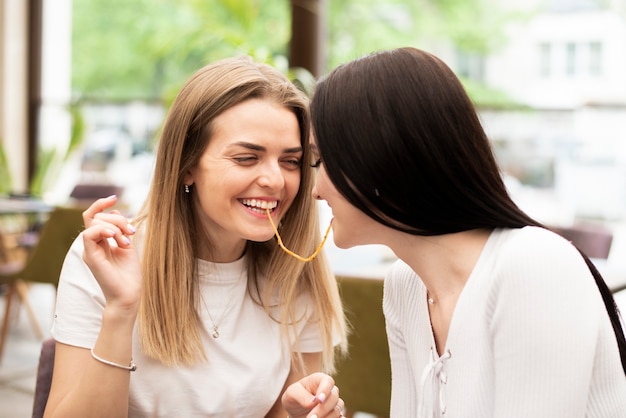 Free photo girls having fun with a spaghetti noodle