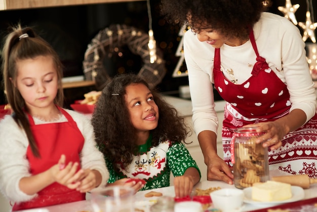 Girls helping mom making cookies for Christmas