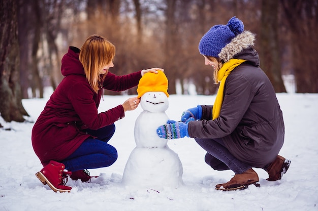 Free Photo girls molding a snowman