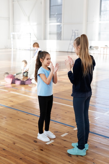 Girls playing game at gym full shot