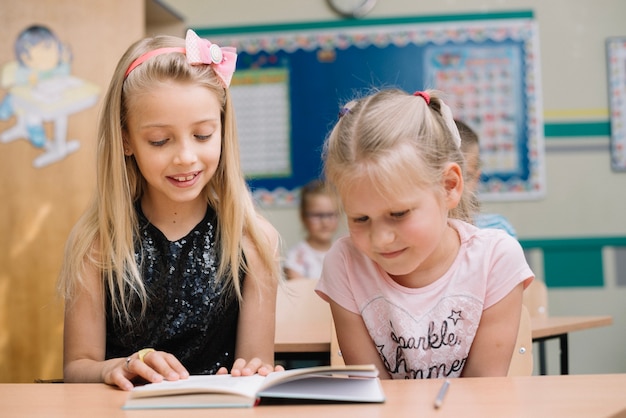 Girls reading book in classroom