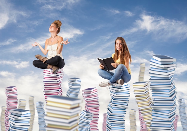 Girls sitting on mountains of books