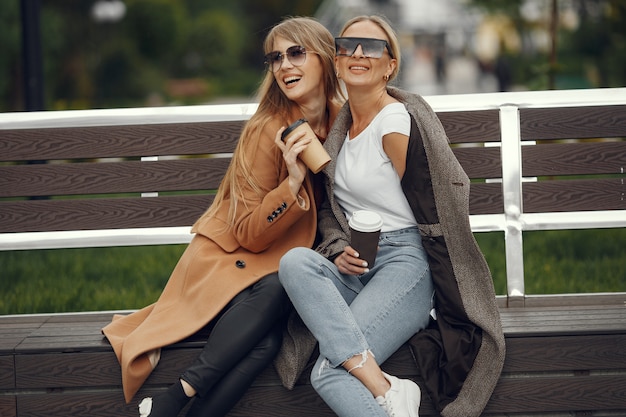 Girls sitting in a spring sity and hold coffee in her hand