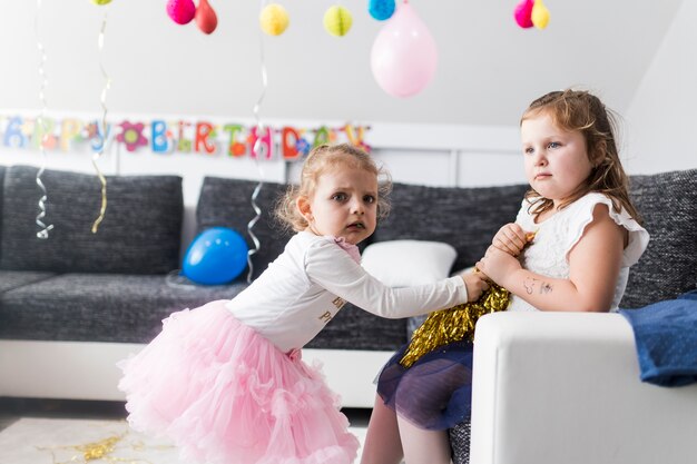 Girls struggling for tinsel on party