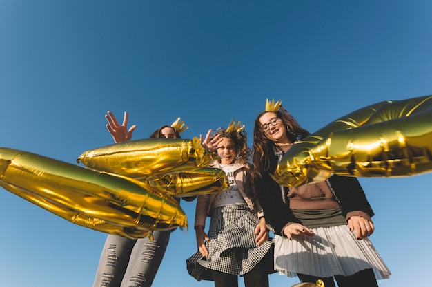 Free photo girls throwing letter-shaped balloons