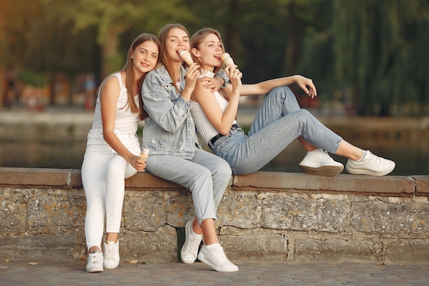 Girls walking in a spring city and hold ice cream in hand