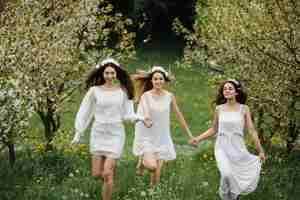 Free photo girls in white dress walking on the field