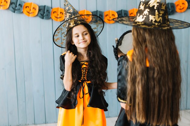 Girls in witch costumes standing opposite