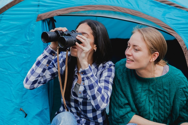 Free Photo girls with binoculars sitting in the tent