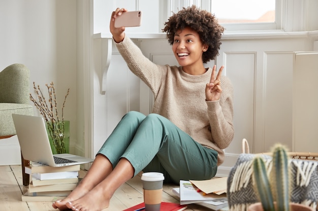 Glad black woman makes peace sign 