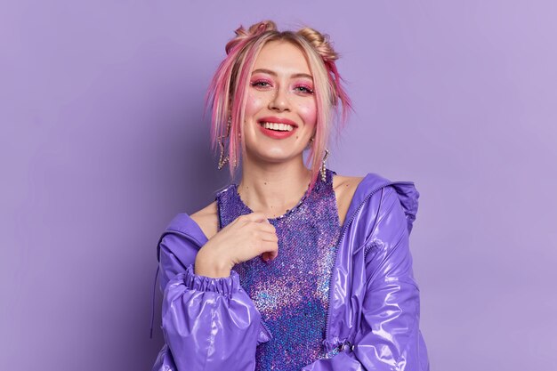 Glad blonde beautiful European woman with bright vivid makeup dressed in fashionable clothes poses 