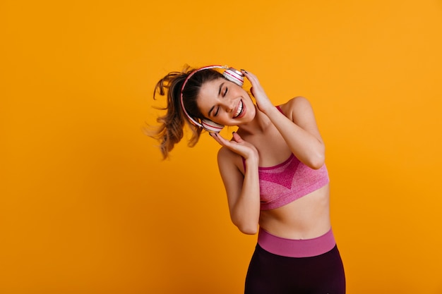 Glad woman doing exercise and listening to music