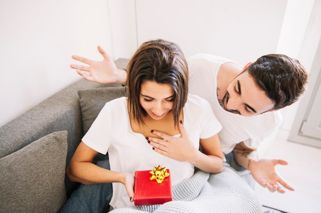 Glad woman receiving present from man