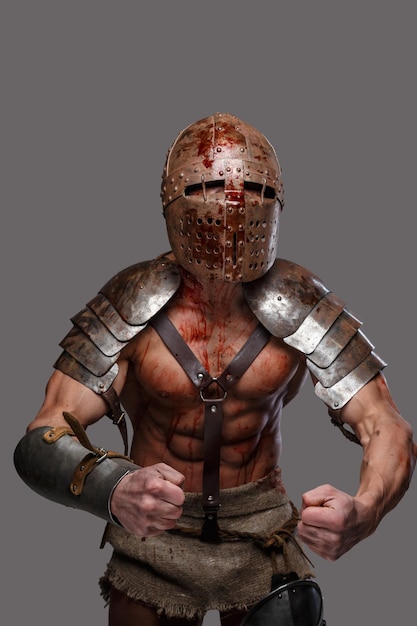 Gladiator in helmet with muscular body shows his strength