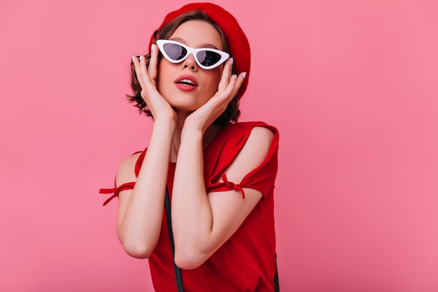 Free photo glamorous french lady touching her sunglasses. magnificent white woman with short wavy hair.