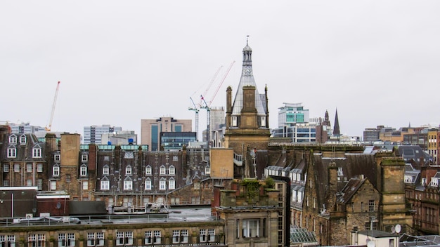 Free photo glasgow cityscape united kingdom roofs of multiple old residential and modern buildings cloudy