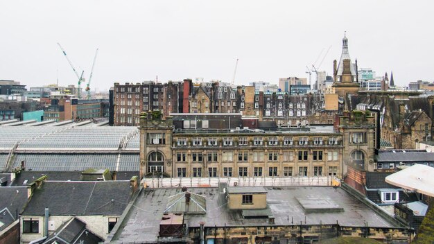 Free photo glasgow cityscape united kingdom roofs of multiple old residential and modern buildings cloudy