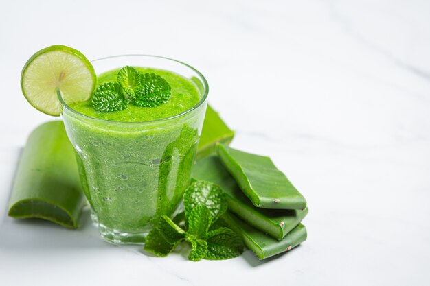 glass of aloe vera juice put on white floor