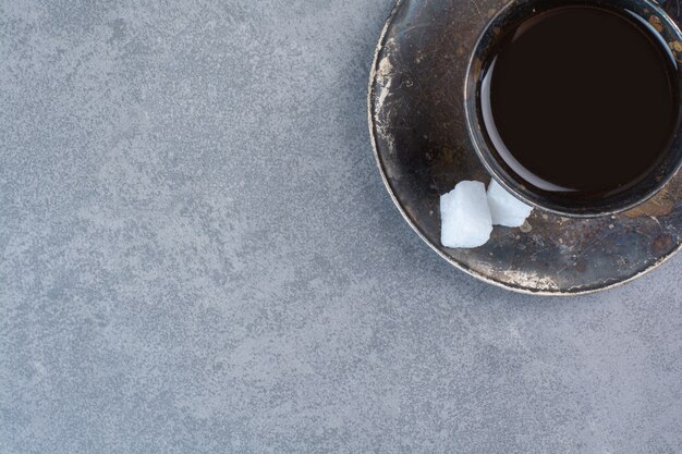 A glass of aroma dark tea on gray table.