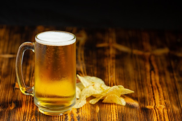 A glass of beer is placed on the wooden floor.