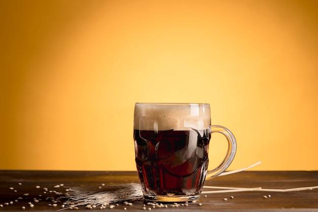 Free photo glass of beer with spike barley on wooden table