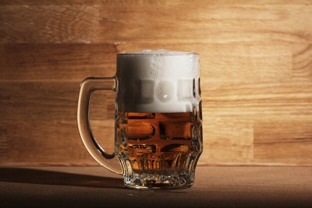 Glass of beer over wooden surface