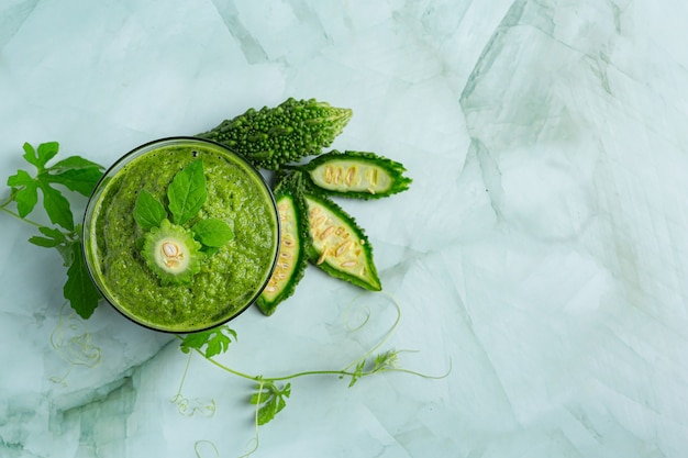 a glass of bitter gourd smoothie with shopped bitter gourd