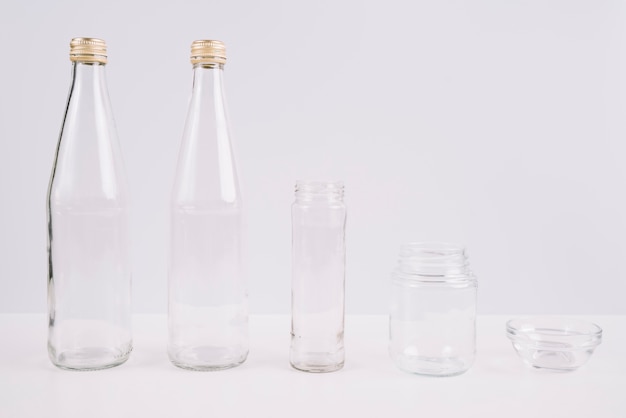 Free photo glass bottles and cups on white background